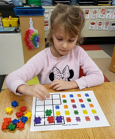 Girl doing math with bears